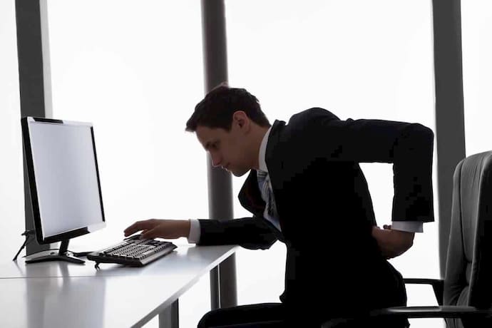 man working at his office with back pain