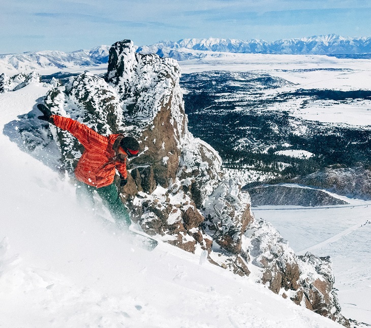 man snowboarding down a mountain 