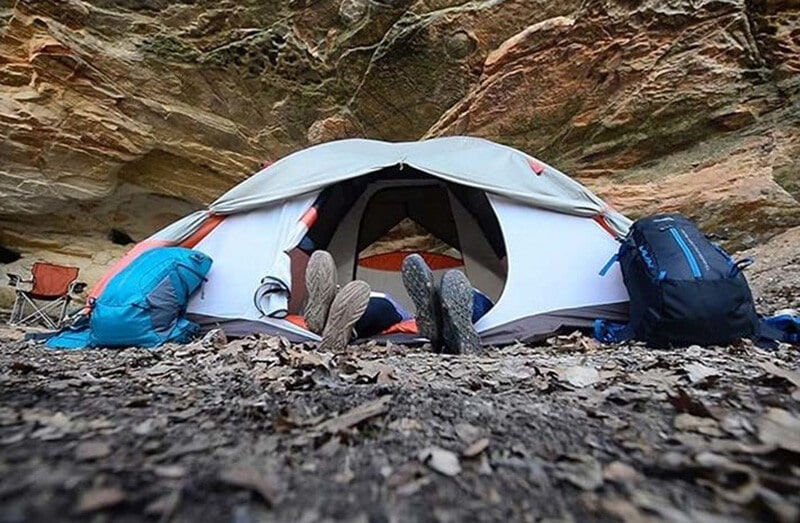 Two people sleeping in a white two person tent for camping
