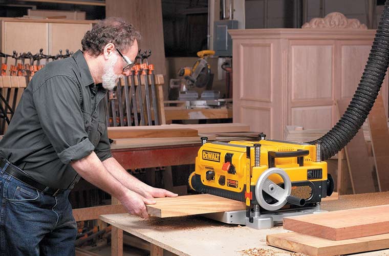 Man working with benchtop planer