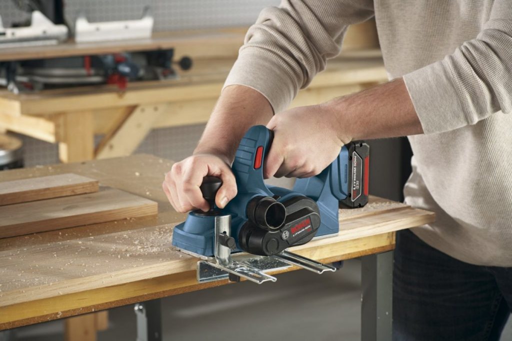 Man removing specified amount of wood with handheld electric planer