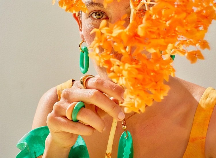 picture of a woman holding a flower wearing resin jewellery