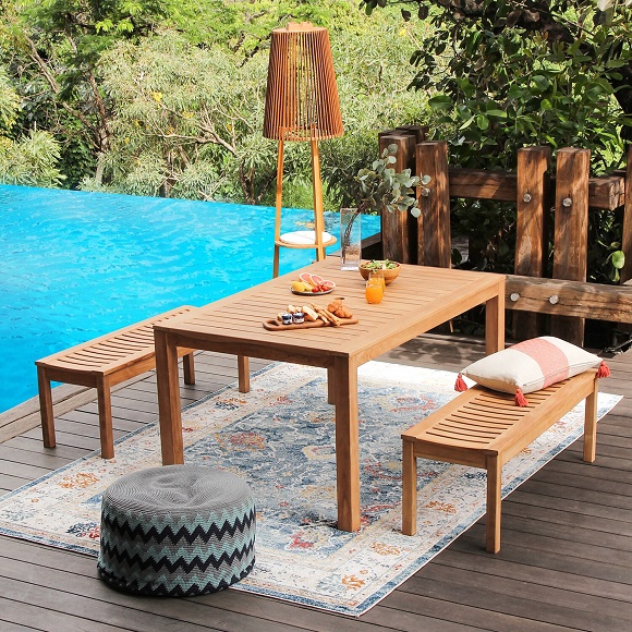 Two wooden benches and a wooden table placed in the patio 