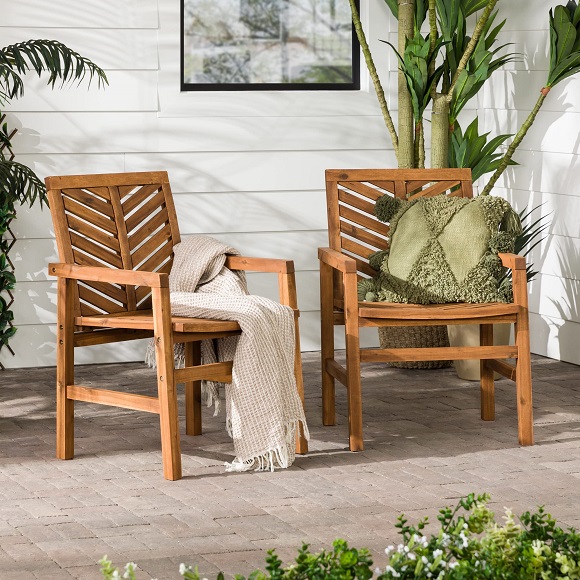 Two teak outdoor armchairs placed in the backyard