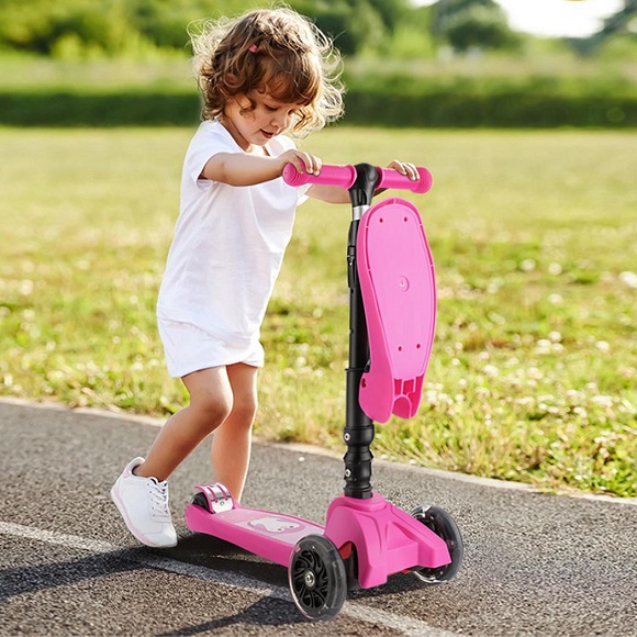 A little girl with a pink scooter
