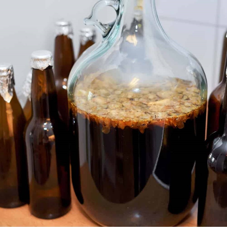 Fermenting beer in a huge glass bottle and some other small glass bottles