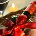 bottle of wine wrapped with a red ribbon